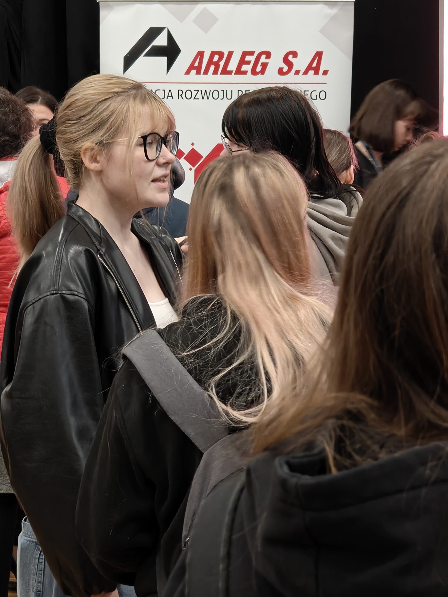 Tłum odwiedzających targi pracy na tle baneru reklamowego firmy ARR ARLEG SA