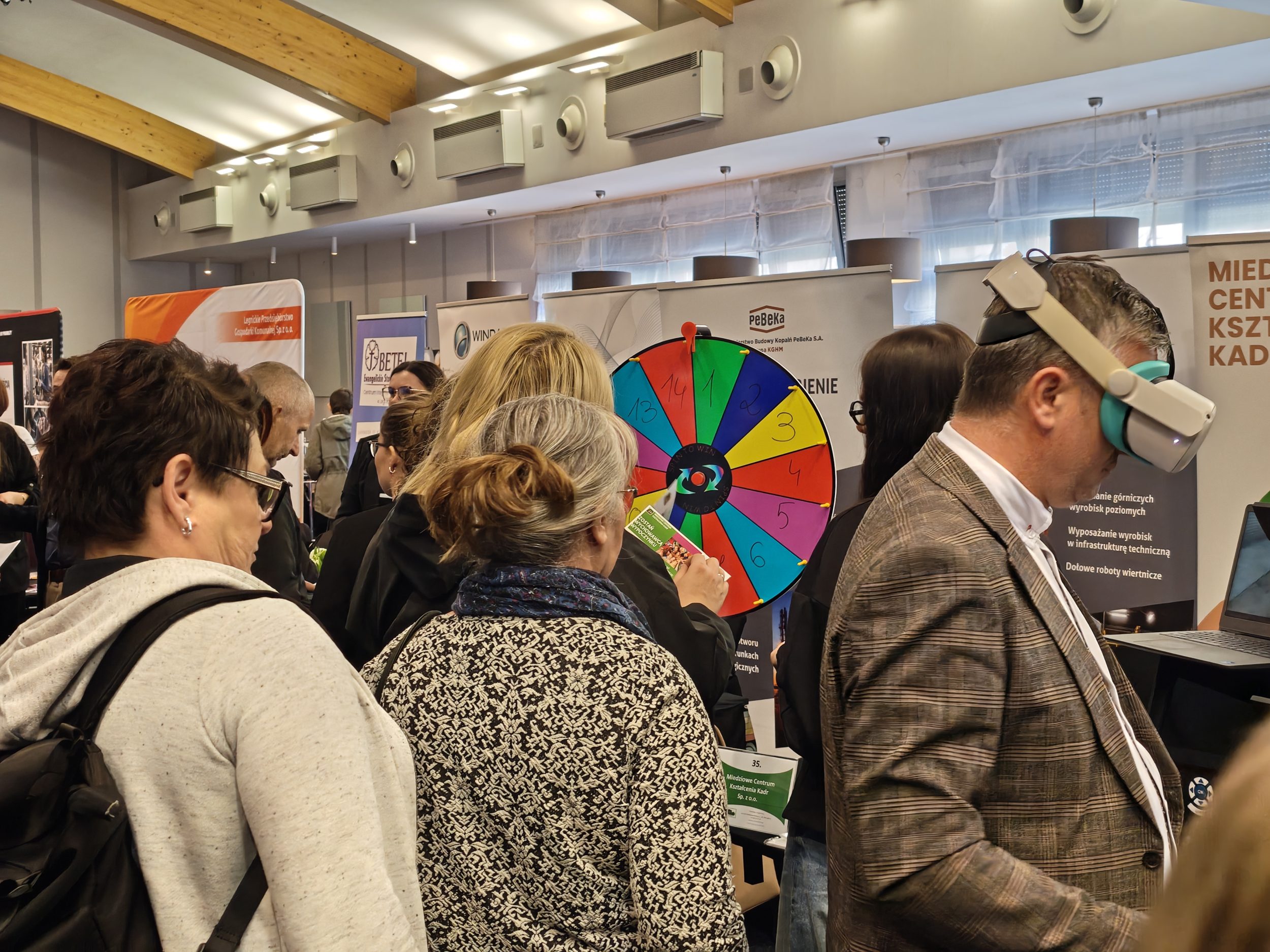 Fotka osób odwiedzających jedno ze stoisk.